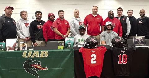 Morgan County seniors Jaylen Elder (2) and Draco Frazzitta (18) pose for a picture with their coaches during a signing ceremony on Wednesday, Dec. 4. CONTRIBUTED