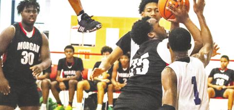 Jaturi Brown (35) attempts to make a layup over two War Eagle defenders. LANCE McCURLEY/Staff