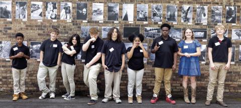Participating students pose in front of their featured wall art. LEIGH LOFGREN/Staff