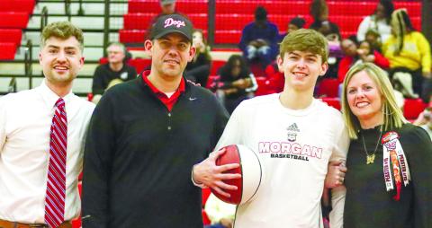 From L to R: Morgan County boys' basketball head coach Cody Anderson, Todd Peaster, Harrison Peaster, and Lindsay Peaster during the Bulldogs' Senior Night ceremony on Feb. 3.