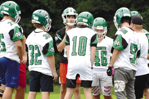 The Nathanael Greene Academy o_ense in the huddle during one of their summer practices. BRENDAN KOERNER/Staff