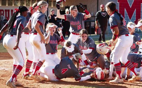 Morgan County players pile on Mallory Martin after defeating Peach County as she scored the game's final run, solidifying the Lady 'Dogs mercy rule win and a trip to Columbus. (LANCE MCCURLEY/Staff)