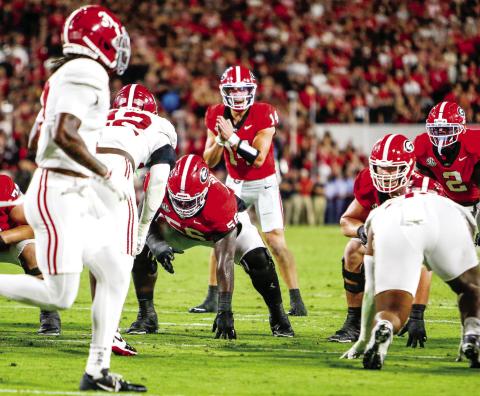 Georgia quarterback Gunner Stockton (14) in the shotgun formation, getting the offense set before a play against Alabama on Sept. 27. LANCE McCURLEY/Staff