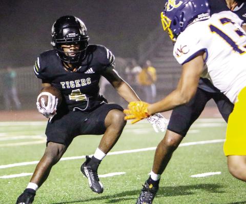 Greene County running back Travez Gibson tries to shake off a Warren County defender and pick up a first down in last Friday’s win over the Screaming Devils. LANCE McCURLEY/Staff