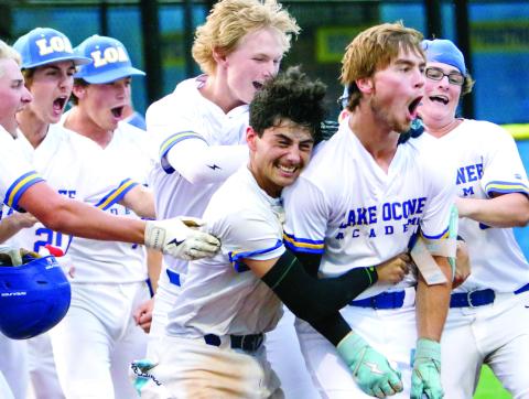 Lake Oconee Academy’s William King (right) celebrates with teammates after his walk-off home run in the bottom of the ninth inning of game three against Clinch County to secure the series win. LANCE McCURLEY/Staff