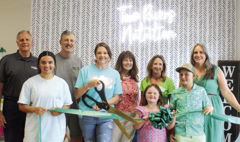 Taylor Wiggins cuts the ceremonial ribbon with the support of her employees, family and Chamber of Commerce staffers. (SKYLA MORRIS/Staff)