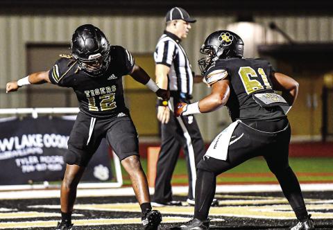 Two Greene County Tigers celebrate after scoring a touchdown against Hancock Central in the first round of the playoffs on Nov. 10. CHARLES JORDAN/Staff