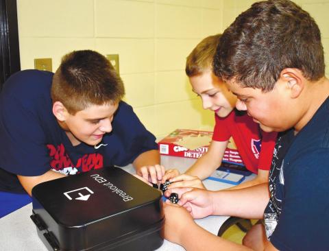 From left, fifth graders Noah Hulett Sinohul, Alexander Rochau and Ian Ortiz work on unlocking the coded lock.