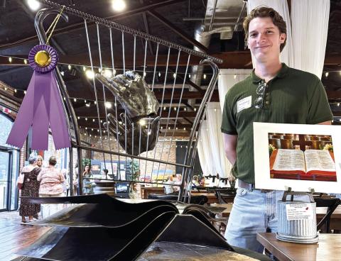 Inspired by an open-book photo of a Bible (right), Brian Danson created an allmetal sculpture featuring a pair of disembodied hands playing a harp that drew enough votes for him as the event’s Peoples’ Choice-winning artist. CONTRIBUTED