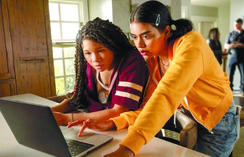Jude, played by Storm Reid, (left) looks at Kevin’s social media with her best friend Veena, played by Megan Suri. TEMMA HANKIN/Sony Pictures