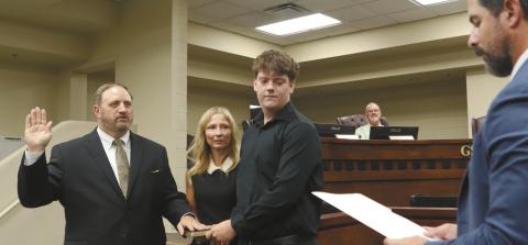 Dr. Arryn Schmuhl stands alongside his wife and son while taking the oath of office as the GCSS superintendent. COURTESY OF GREENE COUNTY SCHOOLS