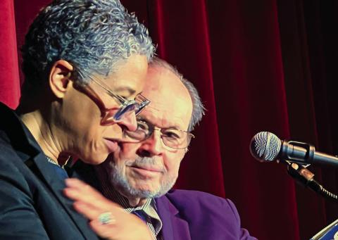 With Larry Moore by her side, Rebecca Walker is emotionally taken by seeing her father’s handwritten inscription inside the front cover of her mother Alice Walker’s first book, a collection of poems published in 1968. IAN TOCHER/Staff