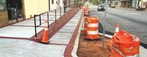 The sidewalk on North Jefferson that has been an embarrassing eyesore for two years looks complete except for the orange barrels, yellow tape and no landscaping. MARK ENGEL/Staff