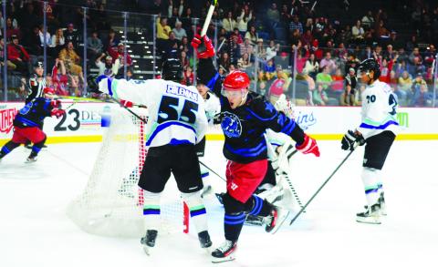 Garret Milan (center) of the Rock Lobsters celebrates after scoring on Mississippi goalie Edward Coffey in the first period of the two teams’ New Year’s Eve game at Akins Ford Arena in Athens. IAN TOCHER/Staff