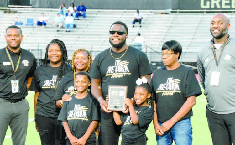 Principal Eddie Hood (far left) and athletic director Derrick Williams (far right) stand with Josh Nesbitt (center) and his family while being recognized at Greene County’s second annual Ring of Honor ceremony. BRENDAN KOERNER/Staff