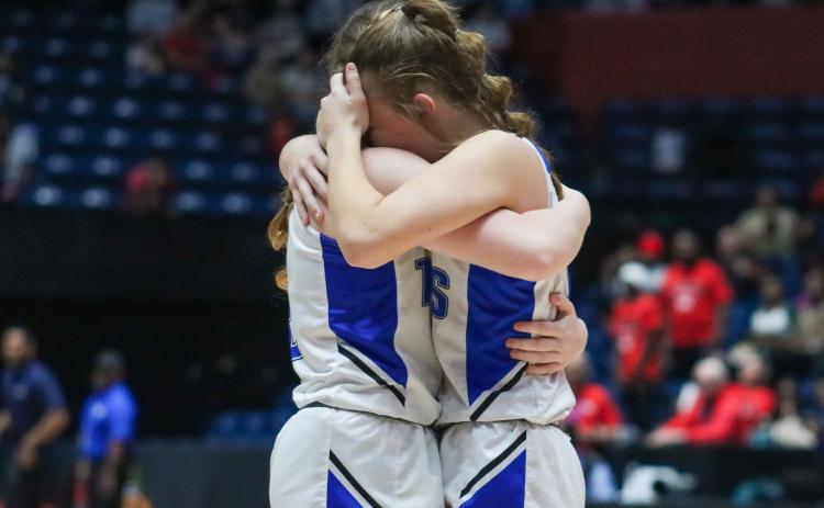 Two Lady Titans' players hug it out after losing to Clinch County on Wednesday at The Macon Centreplex. LANCE MCCURLEY/Staff