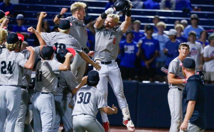Morgan County senior Hudson Reed (2) celebrates with teammates after giving the Bulldogs a 1-0 lead with a solo home run in the fifth inning of Game 2 of the GHSA Class 2A state championship series. LANCE MCCURLEY/Staff