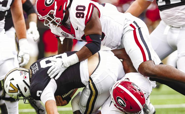 Georgia defensive lineman Tramel Walthour (90) and inside linebacker Smael Mondon Jr. (2) tackle Vanderbilt quarterback Ken Seals (8) during Saturday’s TONY WALSH/UGA Athletics game in Nashville.