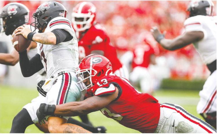Georgia sophomore edge rusher Mykel Williams (13) brings down South Carolina quarterback Spencer Rattler. TONY WALSH/UGA Athletics