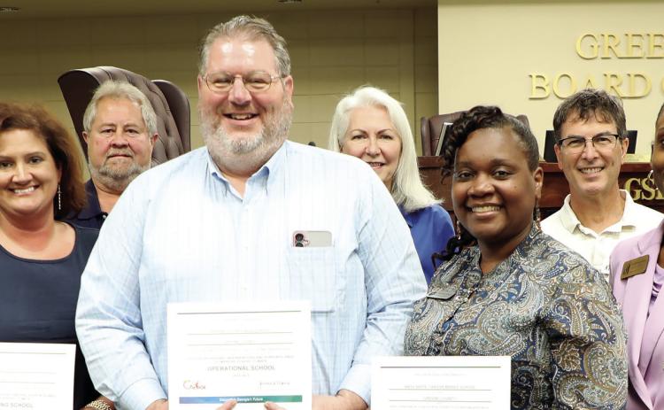 GCPS Principal Ashlie Miller, (left) GCHS Assistant Principal Dr. James Meneguzzo, (center left) and CMS Principal Tanisha Wright (center right) receive their schools’ PBIS recognitions from the state at Thursday night’s BOE meeting from Assistant Superintendent Dr. Rotonya Rhodes (right) along with the BOE members. (CONTRIBUTED)