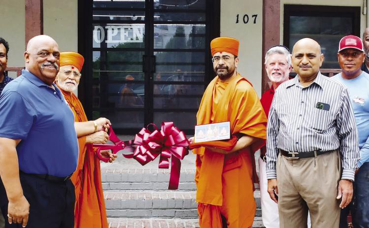Store owner Neil Patel (third from left) was joined by Eatonton Mayor John Reid (blue shirt), two “saints” from BAPS Mandir, and Eatonton-Putnam Chamber of Commerce CEO Robbie King (red shirt), among others, for a Memorial Day ribbon cutting at Stop N Go, on Eatonton’s Martin Luther King Jr. Drive. IAN TOCHER/Staff