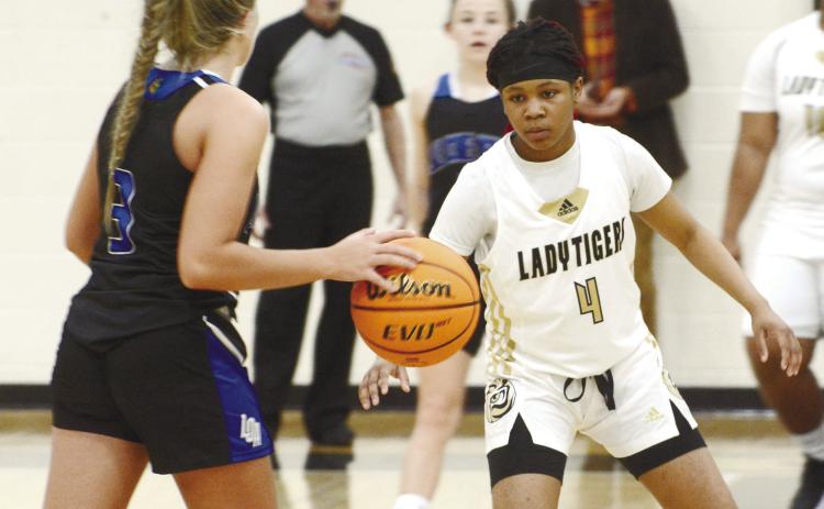 Lady Tigers’ junior Anirah Merritt (4) sets up in a zone defense eyeing down LOA junior Georgia Bosart (3), who brings the ball up the court. BRENDAN KOERNER/Staff