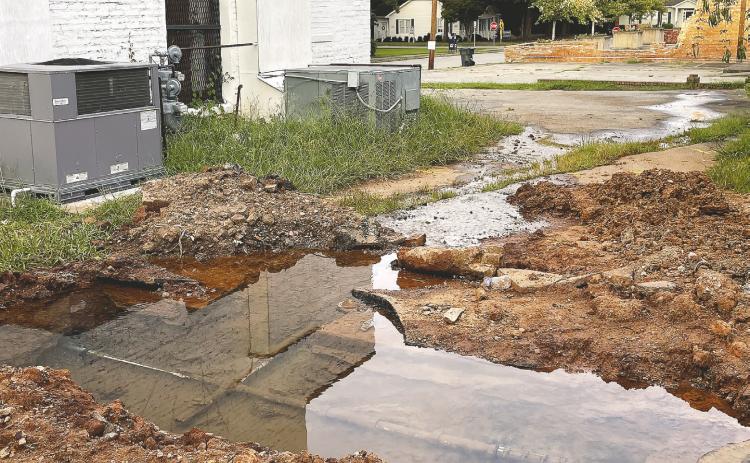 Leaking pipes create runoff behind a downtown property, spilling into the foundation MAUREEN STRATTON/Staff