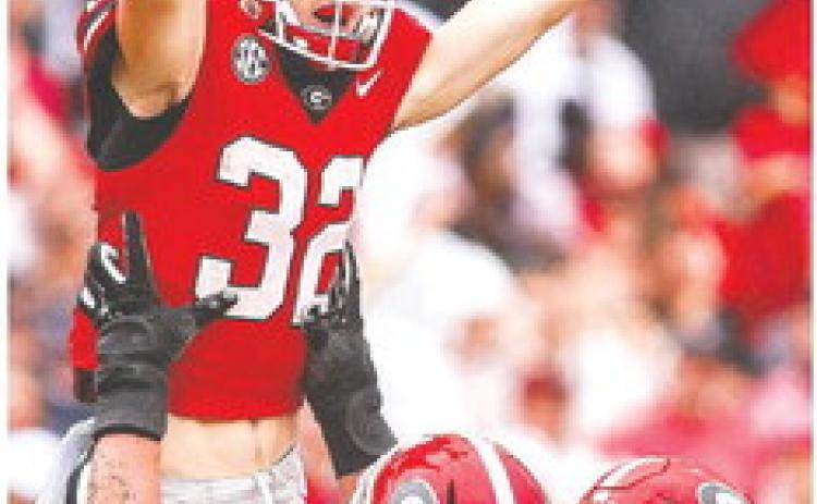 Georgia offensive lineman Tate Ratledge (77) holds up Cash Jones (32) after he scored a touchdown in the fourth quarter of the Bulldogs win over South Carolina last week. TONY WALSH/UGA Athletics