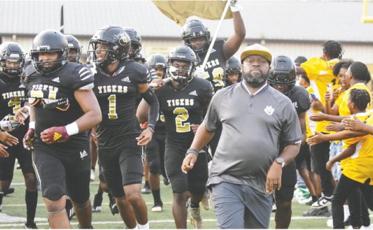 Greene County head coach Terrance Banks leads his team out onto the field in one of the Tigers’ first games of the field. BRENDAN KOERNER/Staff