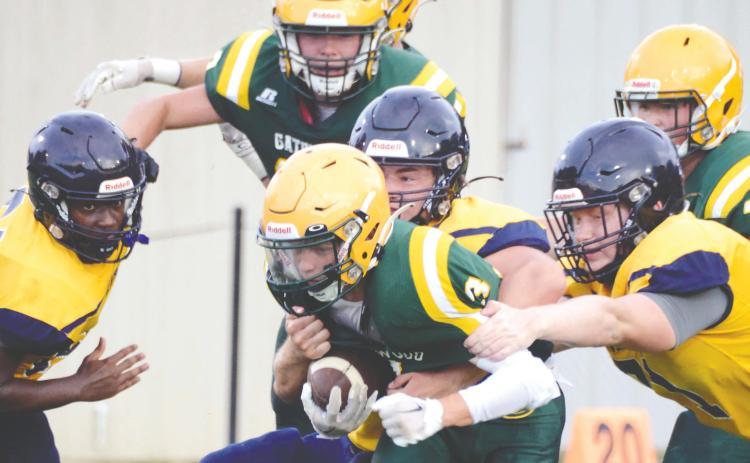 Junior running back Jackson Hewatt (3) is the center of attention for teammates and rivals alike in a first-quarter scrimmage run Friday night at Gatewood Schools in Eatonton, versus the Cavaliers of Mount de Sales Academy. IAN TOCHER/Staff