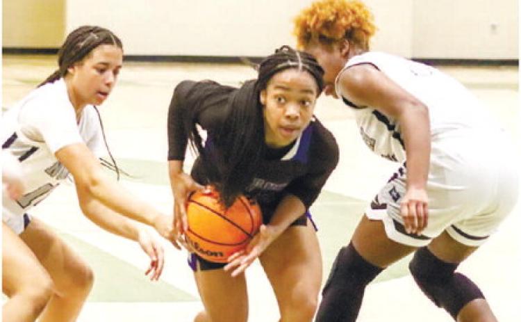 Titans’ guard Jada Williams (22) splits two Wolfpack defenders in last weekend’s game in the Sandy Spiel Showcase at Grayson High School. LANCE McCURLEY/Staff