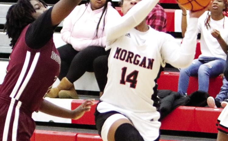 Morgan County junior Jaden Young (14) scored a team-high 18 points during a win over Dougherty during the first round of the Class AAA state playoffs. LANCE McCURLEY/Staff
