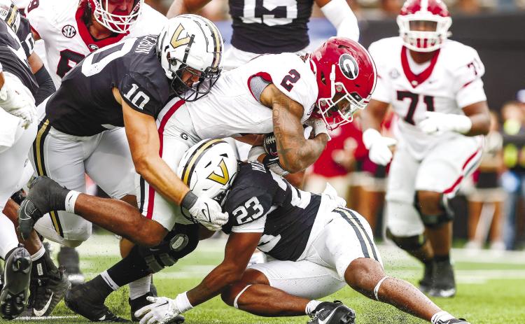 Georgia running back Kendall Milton (2) dives for extra yards as a pair of Vanderbilt defenders try and bring him down. TONY WALSH/UGA Athletics